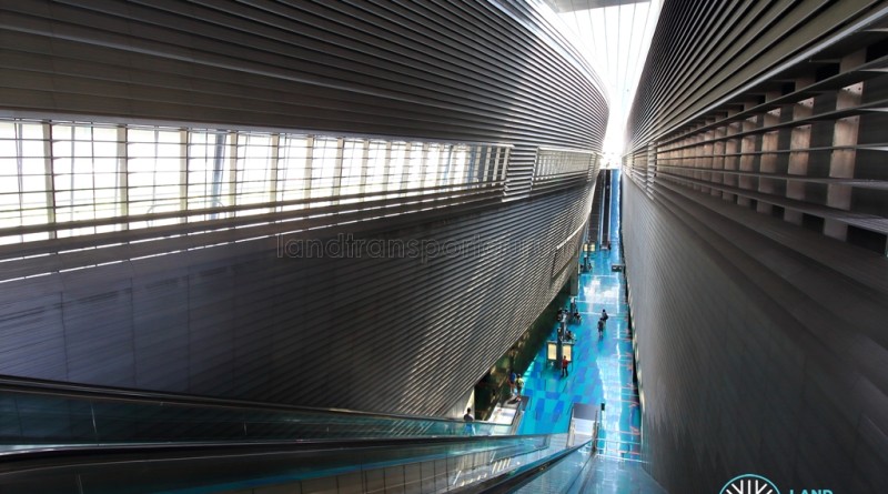 Stadium MRT Station - Overhead view of platform from concourse level, with daylight reaching the lower levels of the station