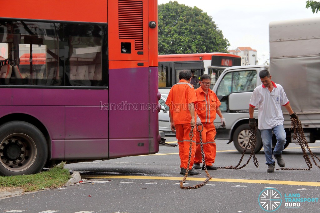 Tow chains are prepared for the towing of the bus